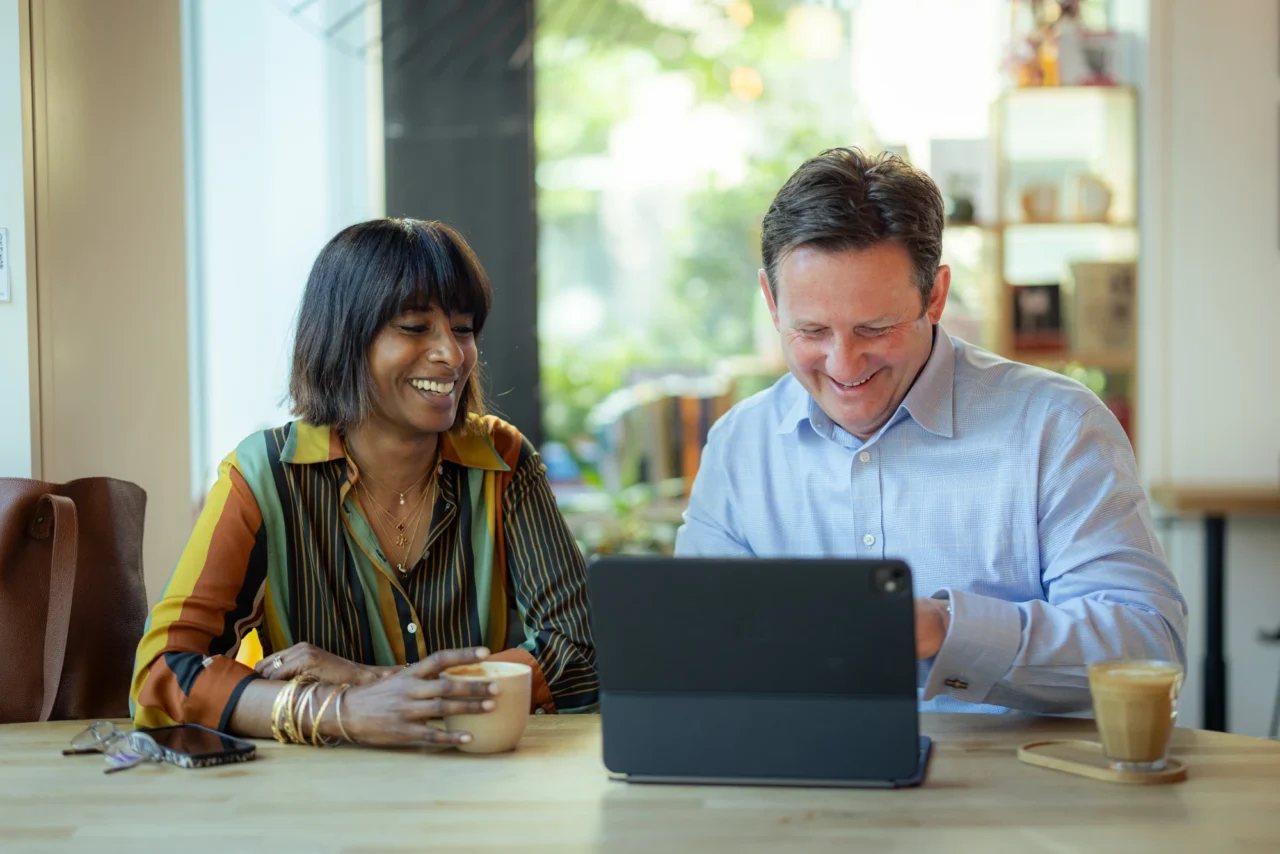 Dana Grey, Chair of Croydon BID, and Matthew Sims, CEO of Croydon BID, discussing work together over a tablet.